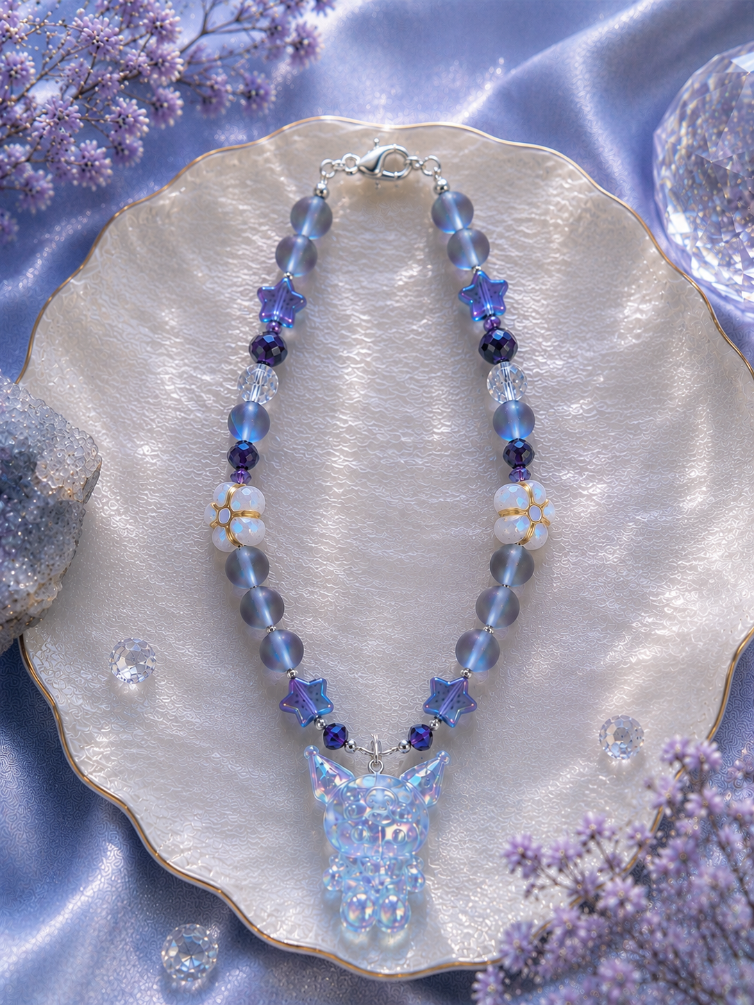 Crystal owl beaded bracelet with iridescent moonstone beads, lavender star crystals, and glowing owl pendant on a shell dish